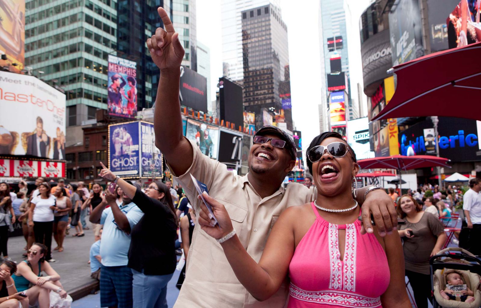 Participants in Times Square reacting to their video on the billboard
