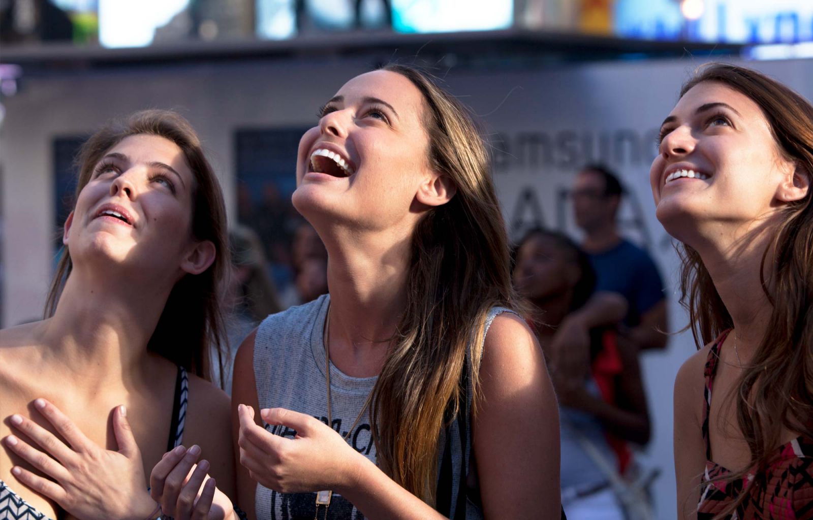 Participants in Times Square reacting to their video on the billboard